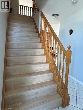 Cambridge apartment for rent - A wooden staircase with a white wall and a brown railing.