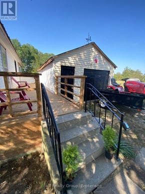 Prince Edward County (Hillier) apartment for rent - A wooden deck with a railing and steps leading to a garage.