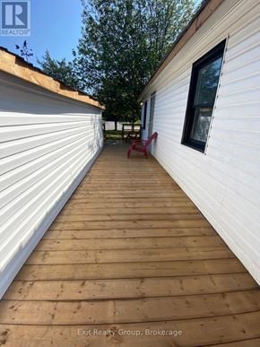 Prince Edward County (Hillier) apartment for rent - A wooden deck leads to a white house with a window.