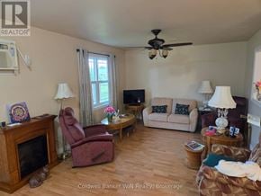 Wellington North (Mount Forest) townhouse for rent - A living room with a fireplace, couch, and chairs.