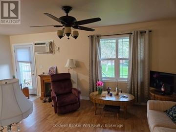 Wellington North (Mount Forest) townhouse for rent - A living room with a red chair and a ceiling fan.
