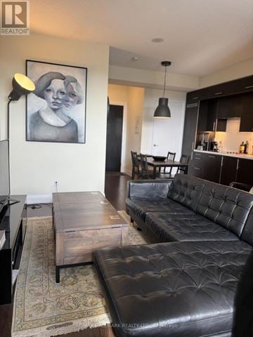 Toronto (Willowdale East) condo for rent - A living room with a black leather couch and a coffee table.