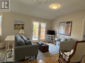 Toronto (Leaside) apartment for rent - A living room with a grey couch and a painting of a woman on the wall.