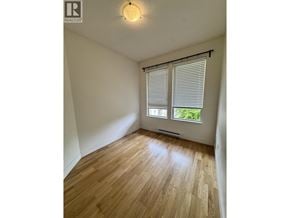 Vancouver apartment for rent - A room with wooden flooring and a window with blinds.