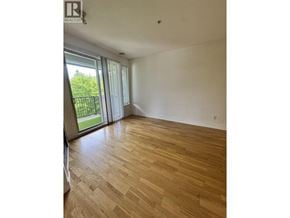 Vancouver apartment for rent - A room with wooden flooring and sliding glass doors.