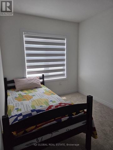 Thorold (Hurricane/Merrittville) townhouse for rent - A bedroom with a bed and a window with blinds.