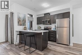 Beamsville townhouse for rent - A modern kitchen with a bar stool and a refrigerator.