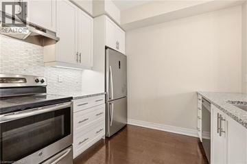 Burlington townhouse for rent - A kitchen with white cabinets and a stainless steel refrigerator.