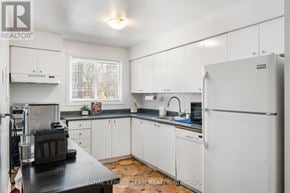 Ottawa townhouse for rent - A kitchen with white cabinets and a black countertop.