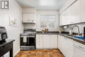 Ottawa townhouse for rent - A kitchen with white cabinets and a black countertop.
