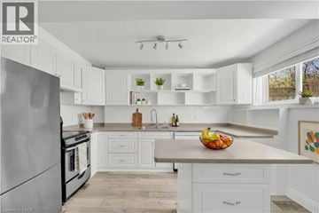 Kitchener apartment for rent - A modern kitchen with white cabinets and a stainless steel refrigerator.