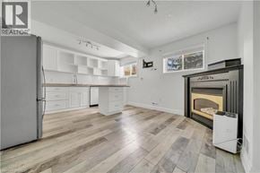 Kitchener apartment for rent - A spacious kitchen with a refrigerator, cabinets, and a fireplace.