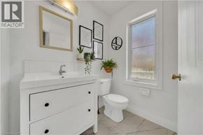 Kitchener apartment for rent - A white bathroom with a sink, toilet, and a window.