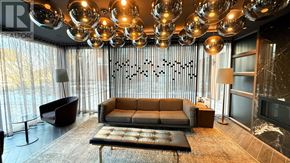 Oakville (Go Glenorchy) condo for rent - A modern living room with a large sofa and a chandelier.