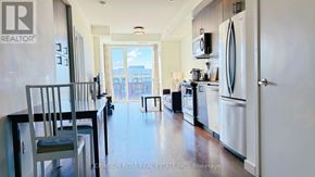 Oakville (Go Glenorchy) condo for rent - A kitchen with a white refrigerator and a dining table with chairs.