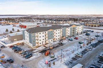 Sylvan Lake apartment for rent - A large building with a parking lot in front of it.