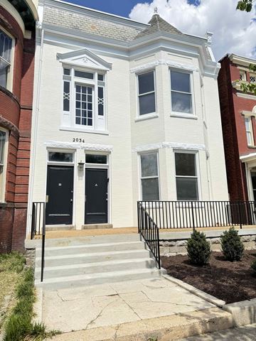 Richmond apartment for rent - A white two story house with black doors and windows.
