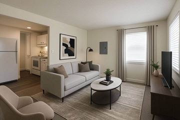 Lakewood apartment for rent - A living room with a grey couch and a white fridge.