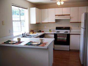 Auburn apartment for rent - A kitchen with white cabinets and a black stove top oven.