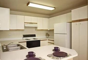 Auburn apartment for rent - A kitchen with white cabinets and a black stove top oven.