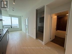 Toronto (Bay Street Corridor) condo for rent - A spacious kitchen and living room with wooden floors and white walls.