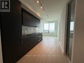 Toronto (Bay Street Corridor) condo for rent - A modern kitchen with dark wood cabinets and a large island.