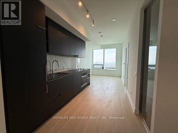 Toronto (Bay Street Corridor) condo for rent - A modern kitchen with dark wood cabinets and a large island.