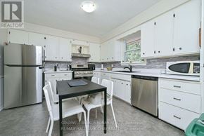New Tecumseth (Alliston) apartment for rent - A kitchen with white cabinets and a black table.