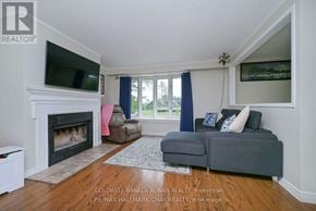 New Tecumseth (Alliston) apartment for rent - A living room with a grey couch and a fireplace.