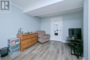 New Tecumseth (Alliston) apartment for rent - A living room with a brown couch, a white door, and a black TV.