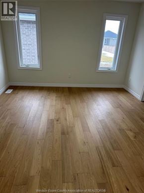 Lakeshore apartment for rent - A room with wooden flooring and two windows.