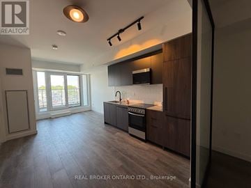 Toronto (Centennial Scarborough) condo for rent - A modern kitchen with dark wood cabinets and a stainless steel stove top oven.