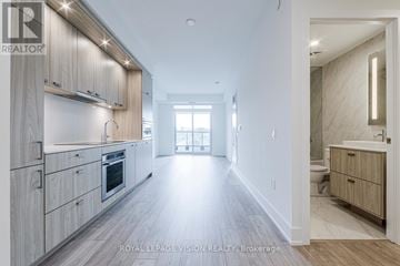 Toronto (Dovercourt-Wallace Emerson-Junction) condo for rent - A spacious kitchen with wooden cabinets and a large island.