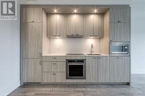 Toronto (Dovercourt-Wallace Emerson-Junction) condo for rent - A modern kitchen with wooden cabinets and stainless steel appliances.