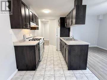 Guelph (Downtown) multi-family for rent - A kitchen with dark wood cabinets and a white stove top oven.