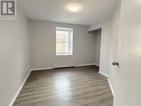 Guelph (Downtown) multi-family for rent - A room with a wooden floor and a window.