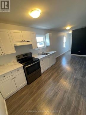 Welland (Lincoln/Crowland) apartment for rent - A kitchen with white cabinets and a black stove top oven.