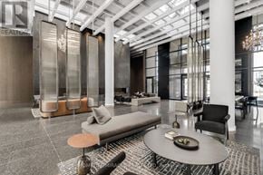 Vaughan (Vaughan Corporate Centre) condo for rent - A modern living room with a glass partition wall and a glass table with a bowl of fruit on it.