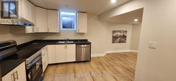 Oakville (Ro River Oaks) apartment for rent - A kitchen with white cabinets and black countertops.