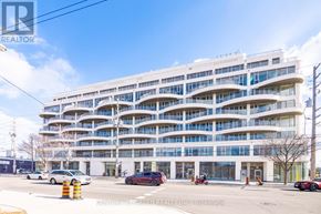 Toronto (Stonegate-Queensway) condo for rent - A large white building with many windows and balconies is in the foreground of the image.