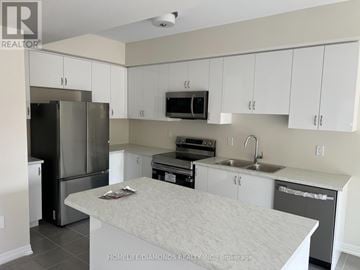 Brantford apartment for rent - A kitchen with white cabinets and a stainless steel refrigerator.