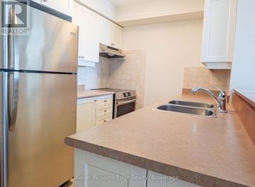 Toronto (High Park North) condo for rent - A kitchen with a stainless steel refrigerator and a sink.