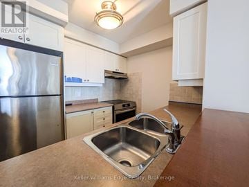 Toronto (High Park North) condo for rent - A kitchen with a stainless steel refrigerator and a sink.