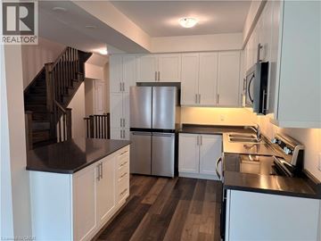 Ancaster townhouse for rent - A kitchen with white cabinets and a stainless steel refrigerator.
