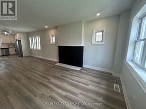 Mississauga (Lakeview) apartment for rent - A spacious room with wood flooring and a black fireplace.