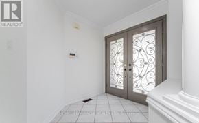 Brampton (Snelgrove) apartment for rent - A white hallway with a glass door and a brokerage sign.
