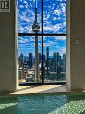 Toronto (Waterfront Communities) condo for rent - A modern building with a pool and a view of the city.