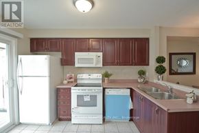 Pickering (Town Centre) townhouse for rent - A kitchen with brown cabinets and a white refrigerator.