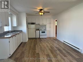 Casselman apartment for rent - A kitchen with white cabinets and a wooden floor.