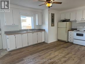 Casselman apartment for rent - A kitchen with white cabinets and a wooden floor.